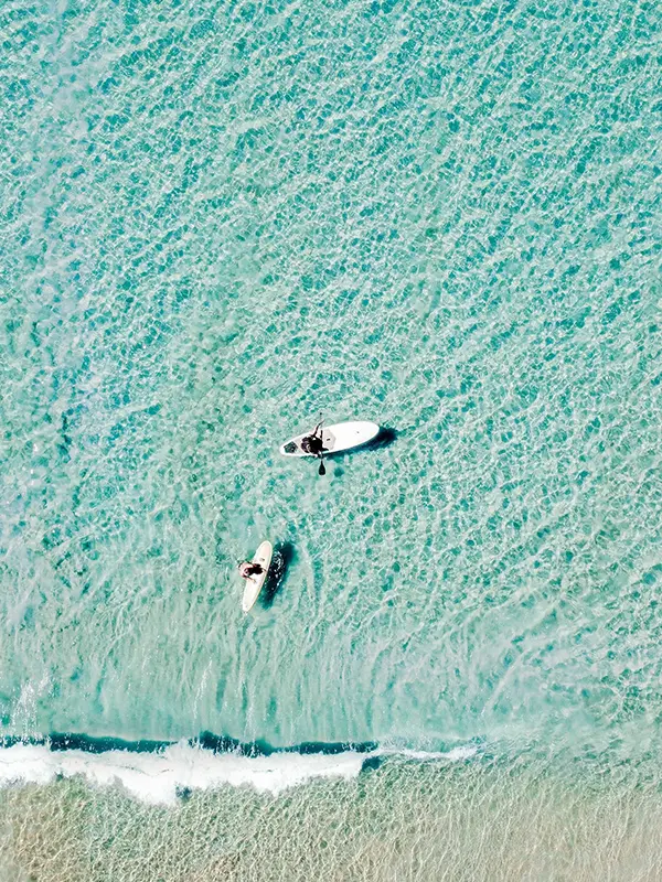 Two people surfing at Sunshine Coast region, in Australia.