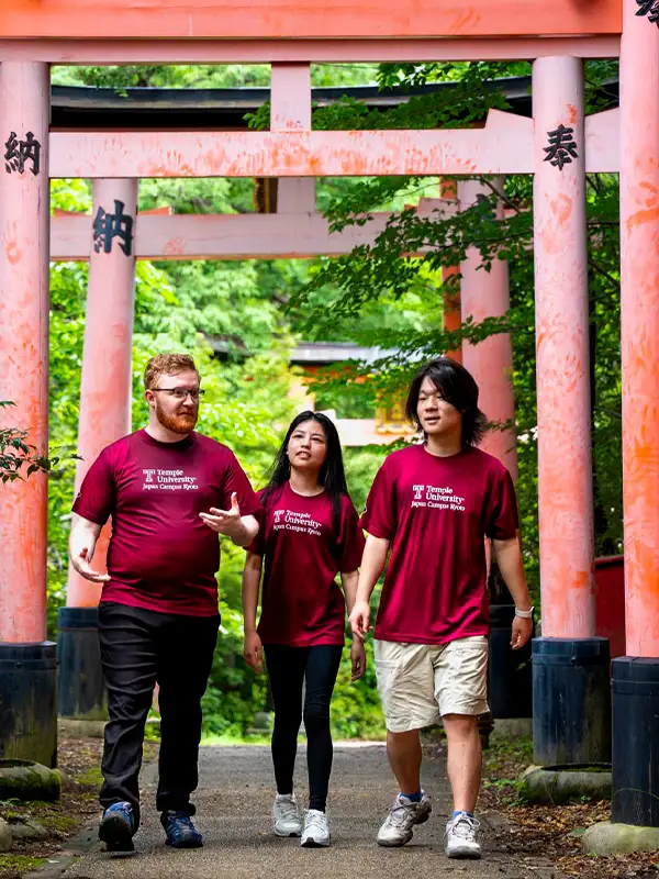 Étudiants de Temple University Japan marchant sous des torii traditionnels