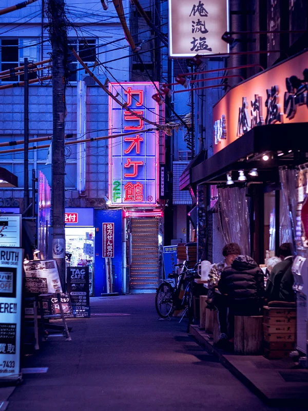 Rue de Tokyo éclairée par des néons avec restaurants et ambiance urbaine japonaise pour étudiants internationaux