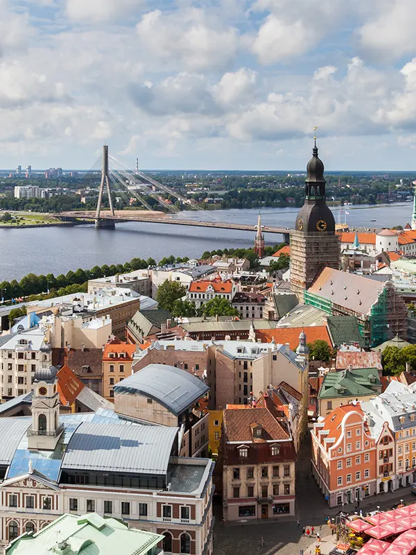 Vue aérienne des toits du vieux Riga avec la tour de la cathédrale, le pont suspendu Vanšu et la Daugava s'étirant jusqu'à l'horizon