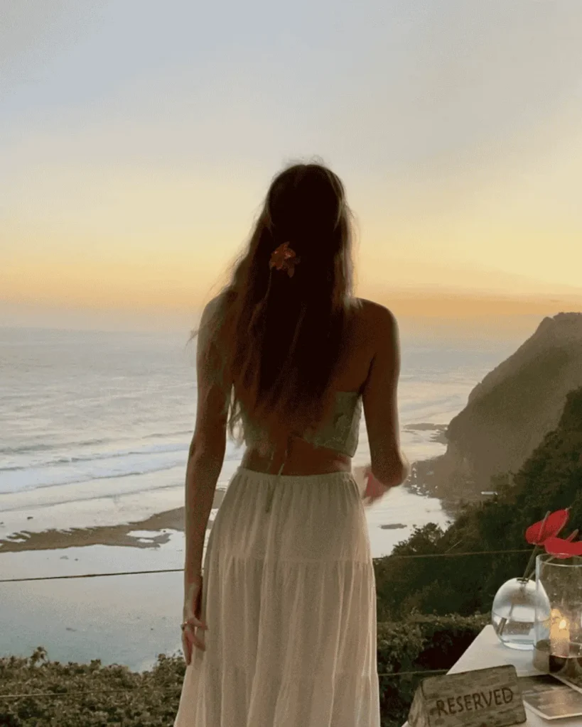 Etudiante à l'étranger devant la mer lors d'un coucher de soleil